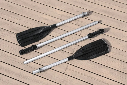 Cuatro remos para bote inflable con mangos de aluminio y empuñaduras negras, dispuestos sobre madera.