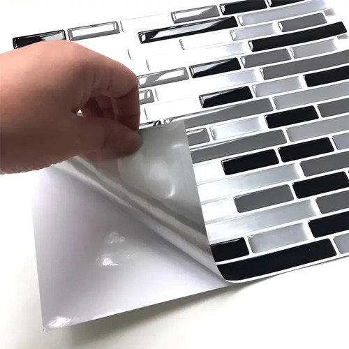 Mano despegando azulejo autoadhesivo mosaico de patrón blanco, gris y negro