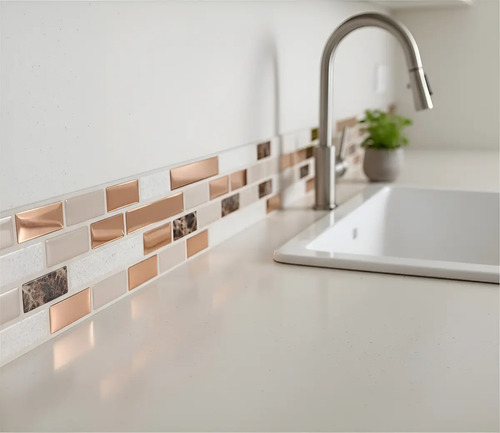 Guarda autoadhesiva mosaico 3D beige y cobre instalada en pared de baño, vista con mesada y bacha blanca