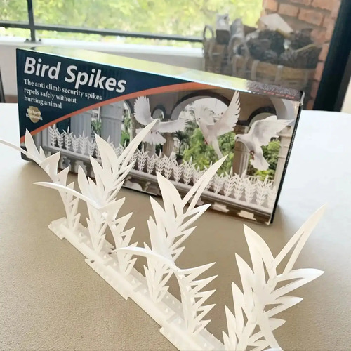 Pinchos espanta pájaros blancos de plástico, vista frontal con caja de producto de fondo