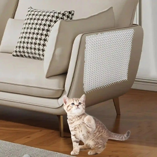 Ahuyentador de gatos con pinchos de PVC instalado bajo un sofá, con gato observando el producto