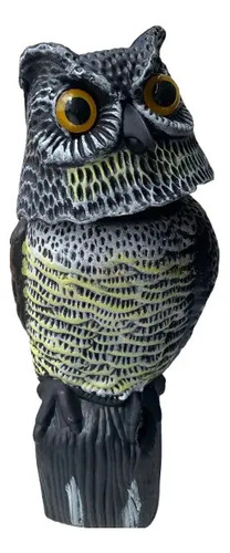 Búho espanta pájaros negro con ojos dorados y detalles en blanco, montado sobre base de madera.