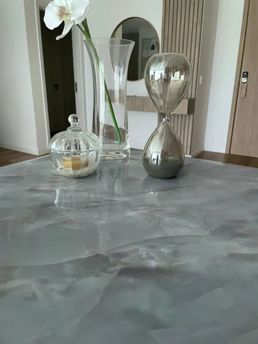 Papel mármol autoadhesivo celeste claro aplicado en mesa con objetos decorativos
