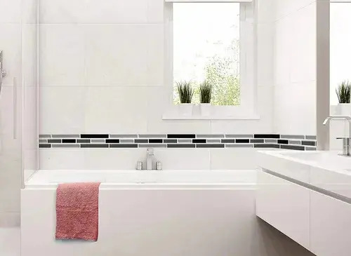 Guarda autoadhesiva mosaico 3D gris instalada en pared de baño sobre bañera blanca