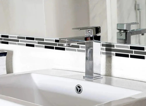 Guarda autoadhesiva mosaico 3D instalada sobre espejo en baño, con patrón de bandas negras y grises