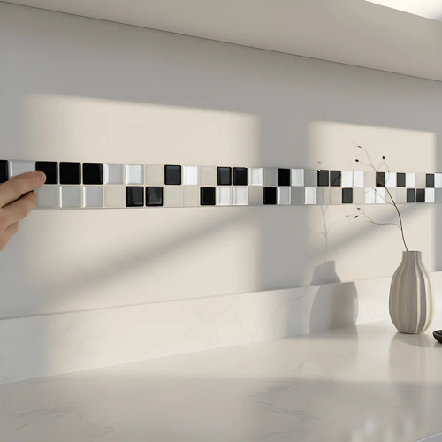 Placas autoadhesivas mosaico 3D en tonos blanco, negro y gris instaladas como guarda horizontal en pared