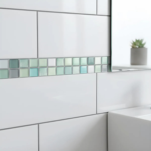 Guarda autoadhesiva 3D verde claro instalada en pared de baño entre azulejos blancos